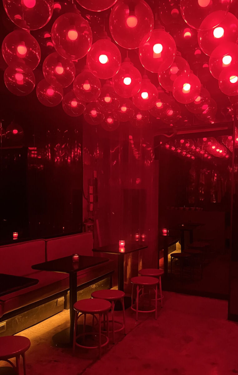 bar con luces rojas y mesas pequeñas