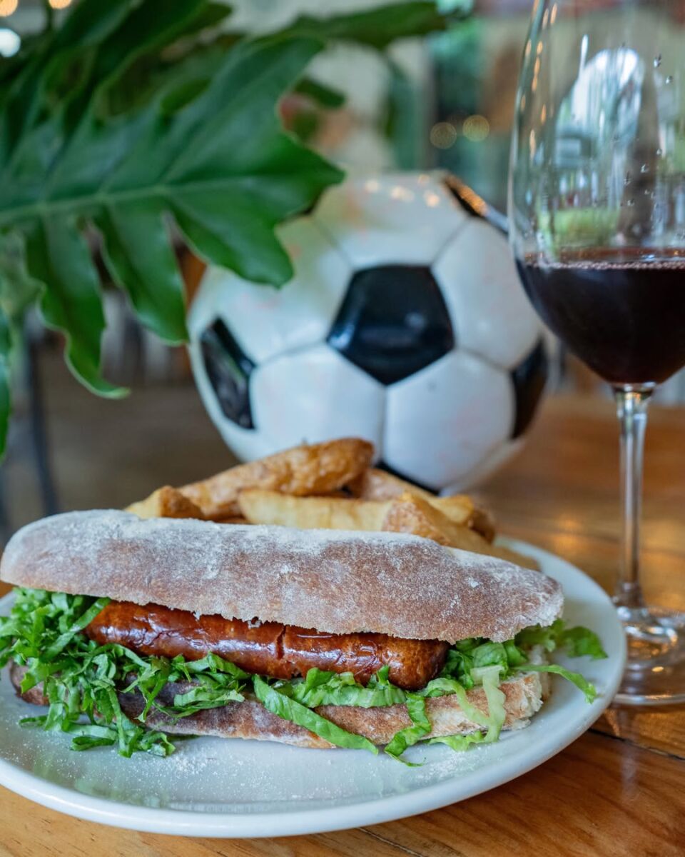 salchicha alemana con balón y una copa de vino atrás
