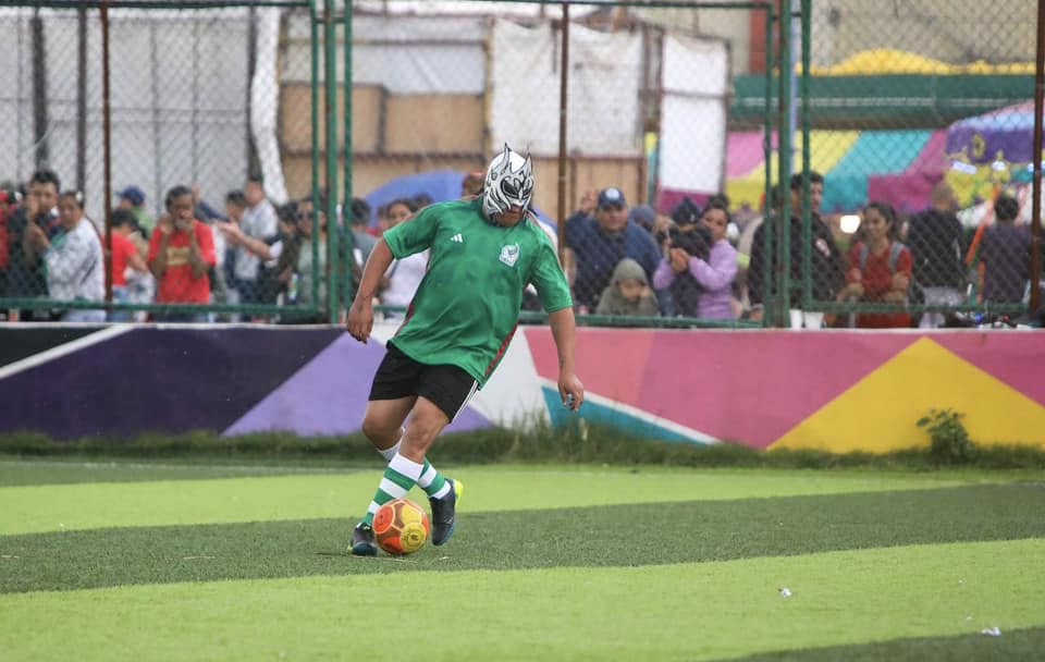 Un hombre con máscara de luchador jugando fútbol en la cancha el Maracaná de Tepito 