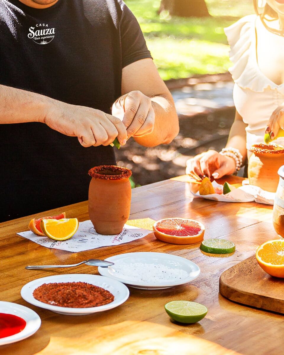 persona preparando un cantarito con limón y chile