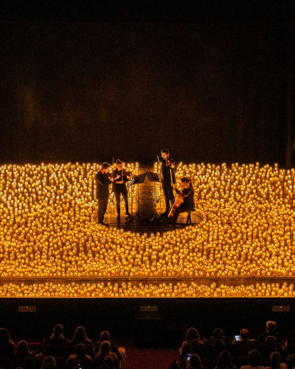 músicos tocando en medio de velas de luz led