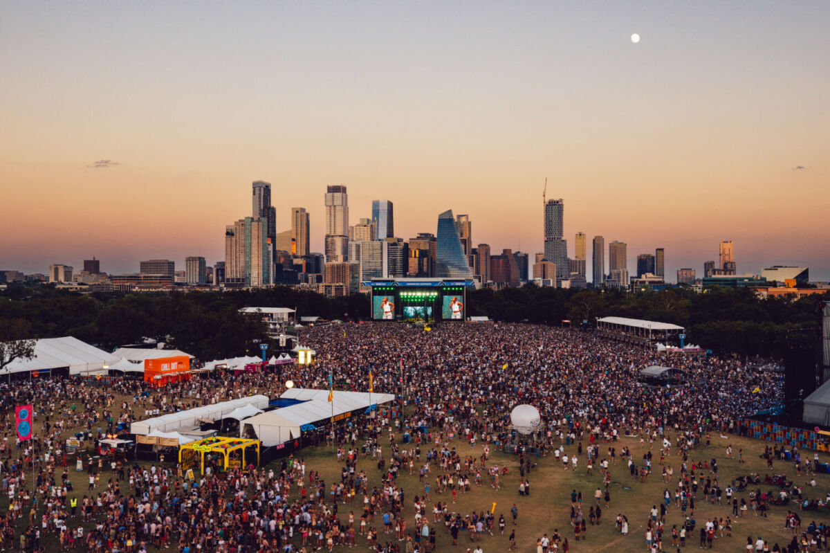 toma aérea del festival acl en austin con el skyline de la ciudad al atardecer