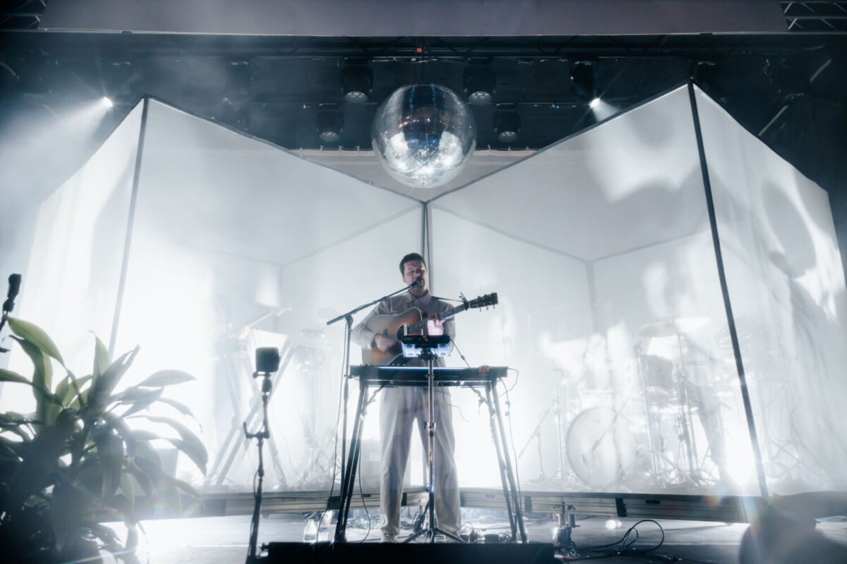 artista tocando el piano y la guitarra entre sombras y luces