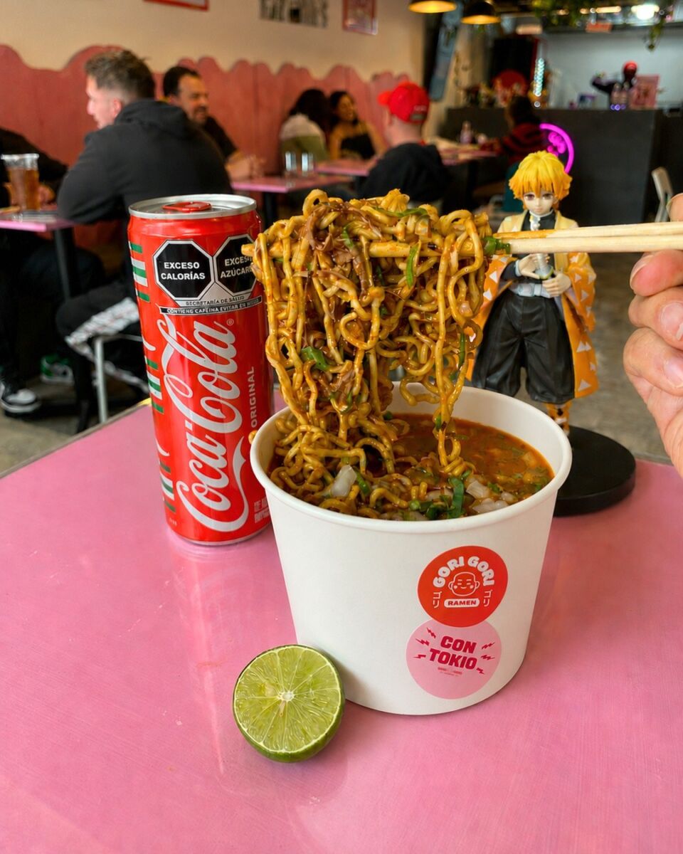 vaso de ramen seco con Coca-Cola y una figura de Demon Slayer