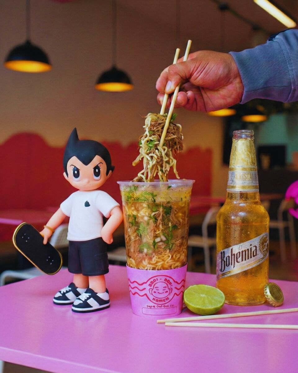 ramen en vaso con una figura de Astro Boy y una cerveza