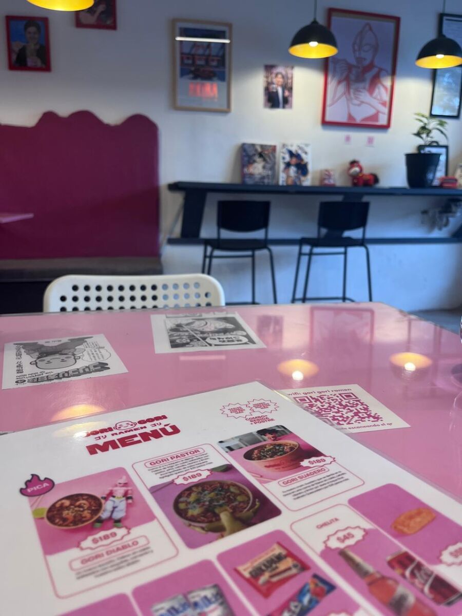 Mesa rosa con menú de Gori Gori Ramen y restaurante de fondo