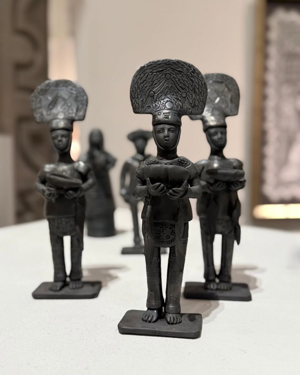 hombres de barro negro con penachos