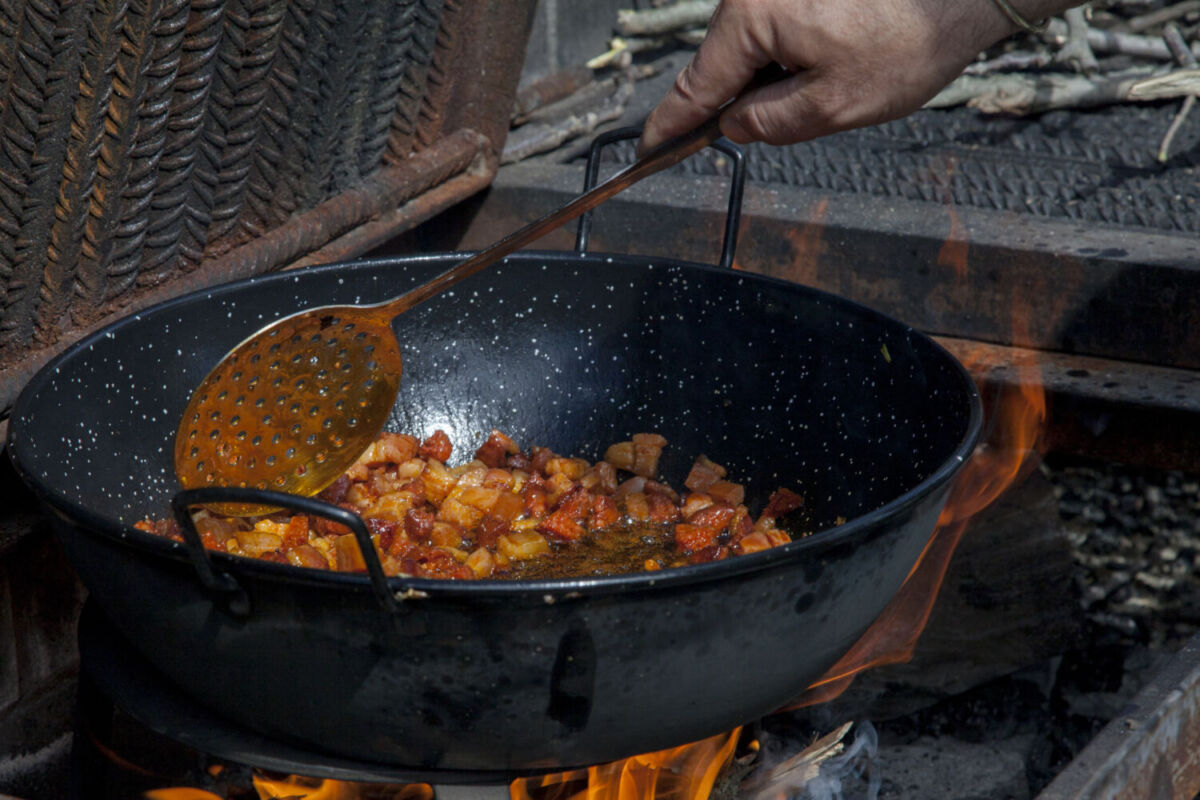 persona cocinando en una sartén migas 