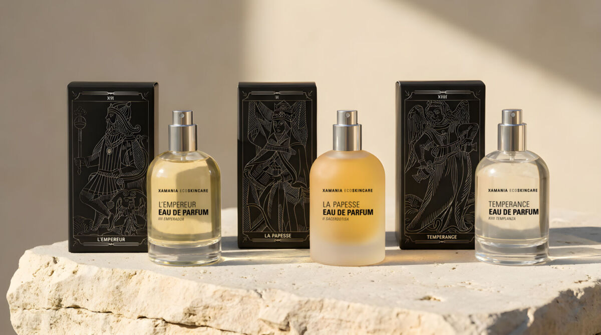 tres perfumes junto a sus cajas con motivos del taro de marsella