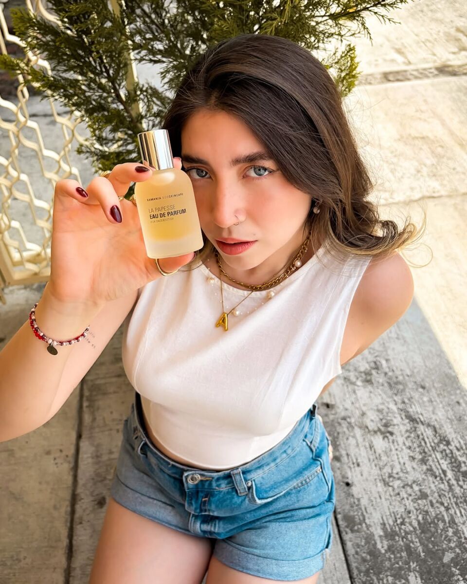 mujer posando con una botella de perfume