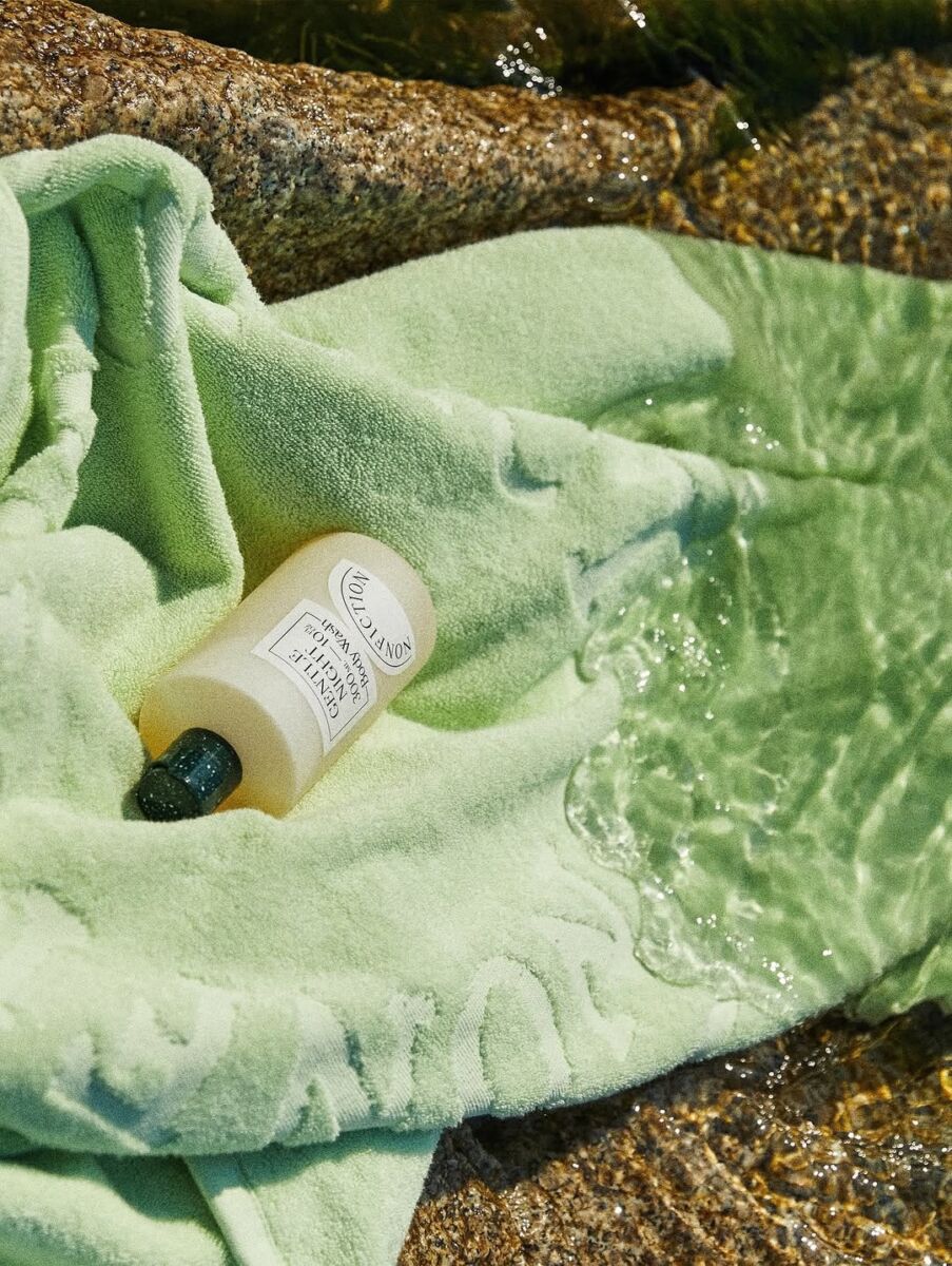 perfume de nonfiction sobre una toalla verde en la playa