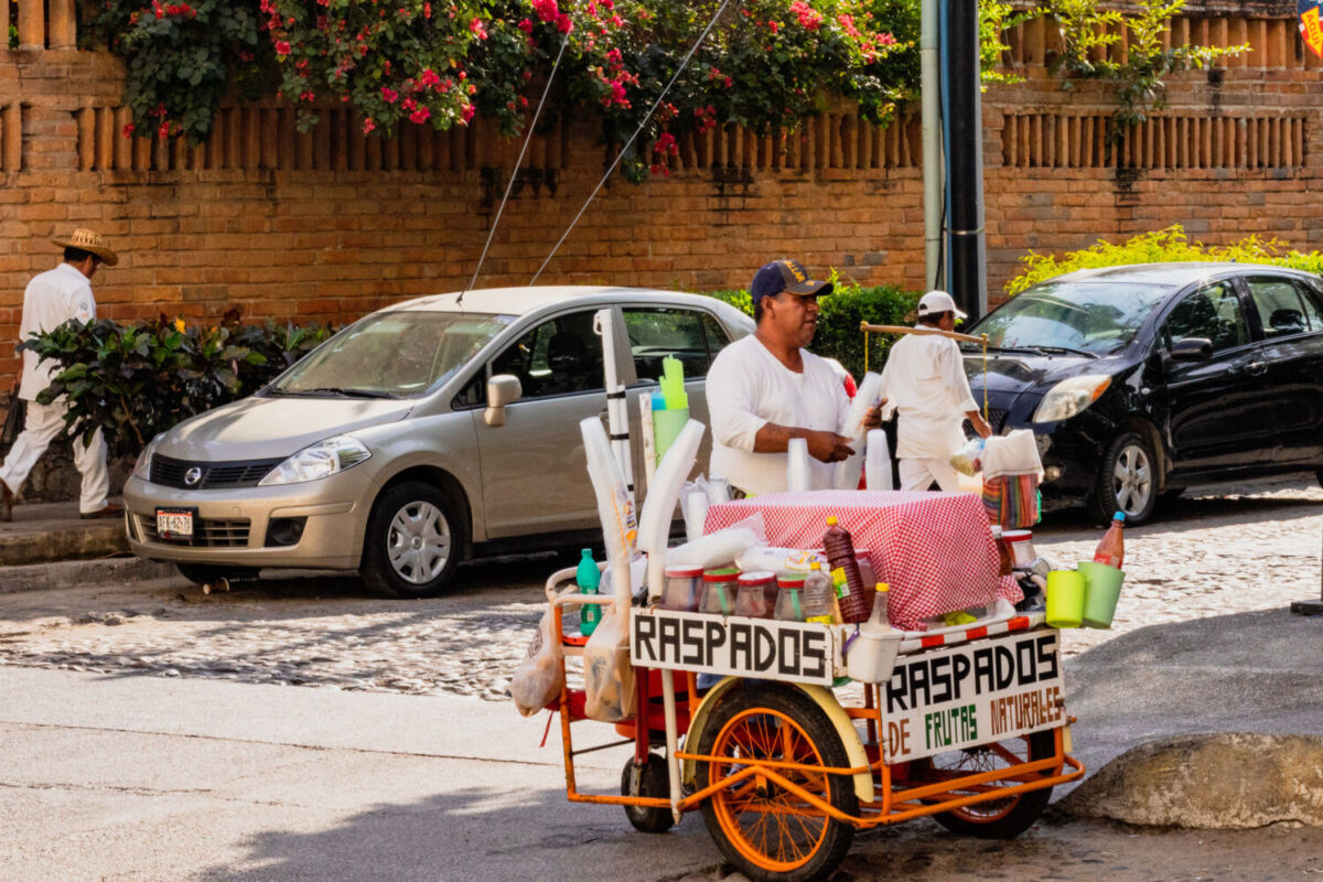 persona en la esquina de la calle vendiendo raspados 