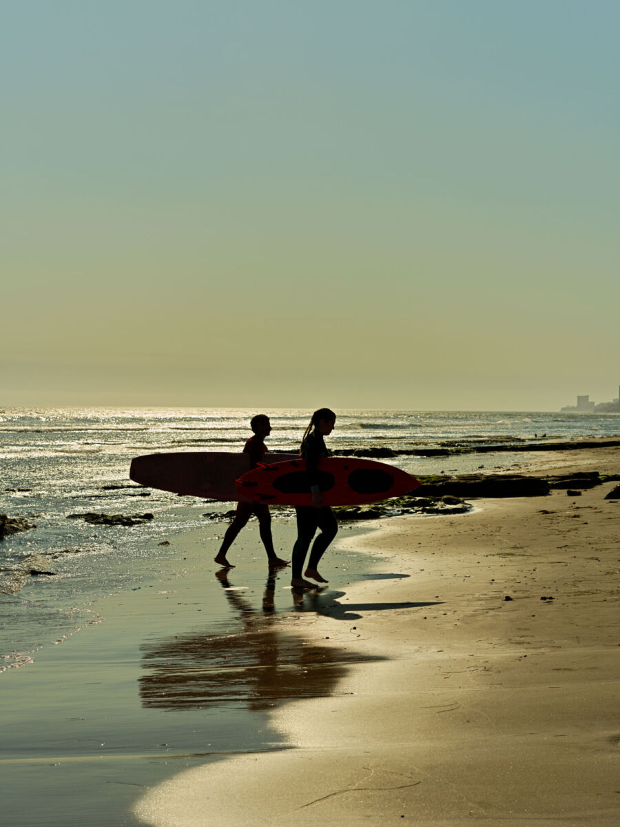 Un par de surfistas saliendo de la playa de Rosarito