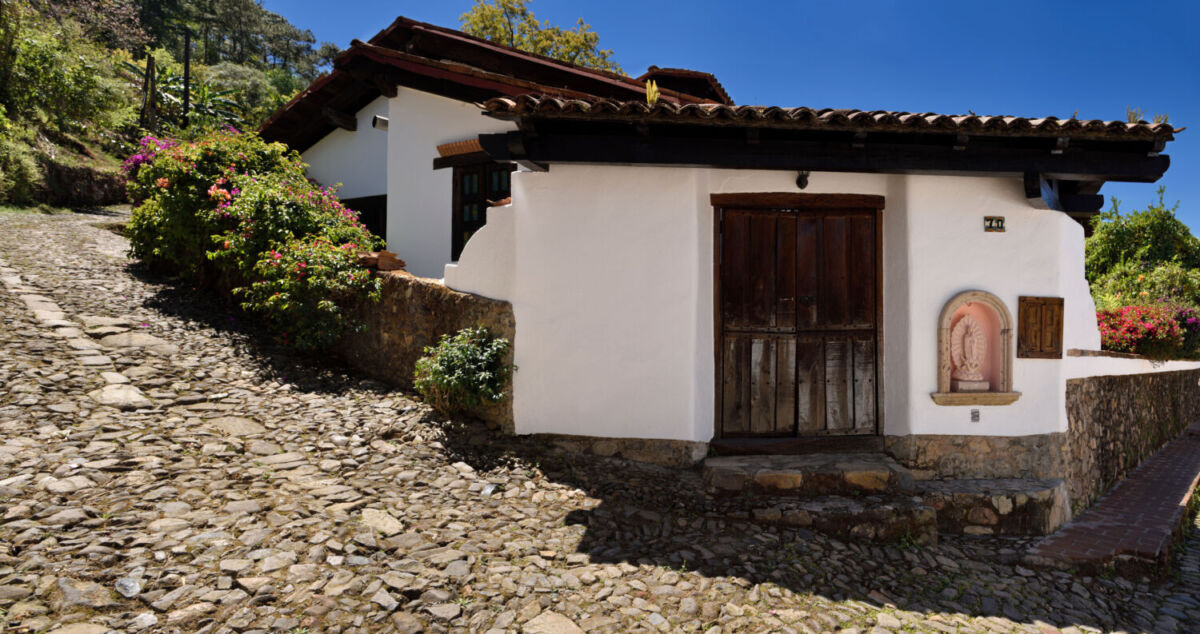 Casa de fachada blanca en una calle empedrada 