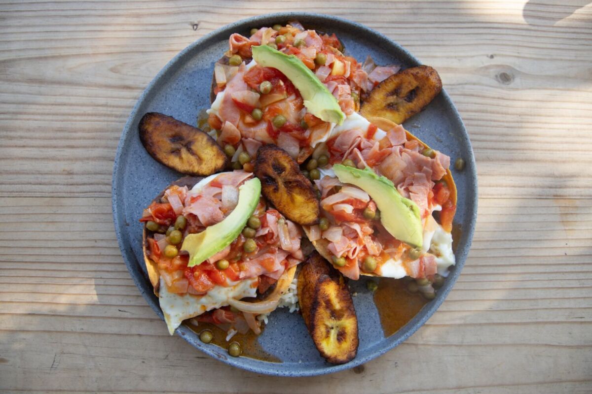 Huevos motuleños yucatecos con tortilla frita, frijoles refritos, jamón, chícharos, jitomate, aguacate y plátano macho, Sisal Yucatán