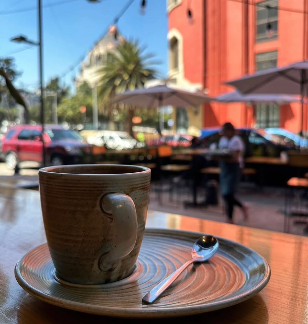 taza de café con monumento a la revolución en el fondo de día