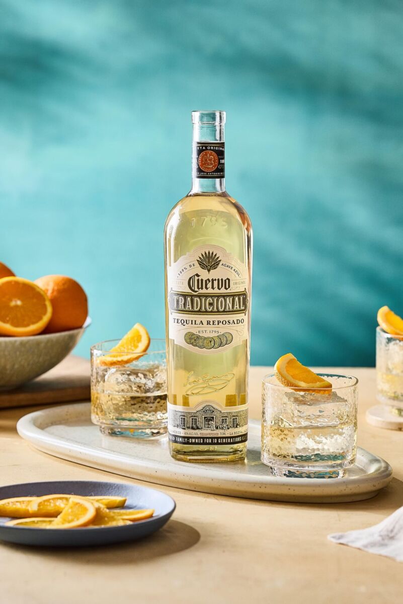botella josé cuervo junto a caballitos con rodajas de naranja