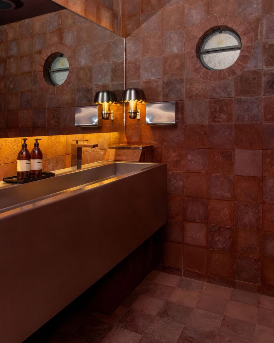 Baño de bar con pared de tezontle