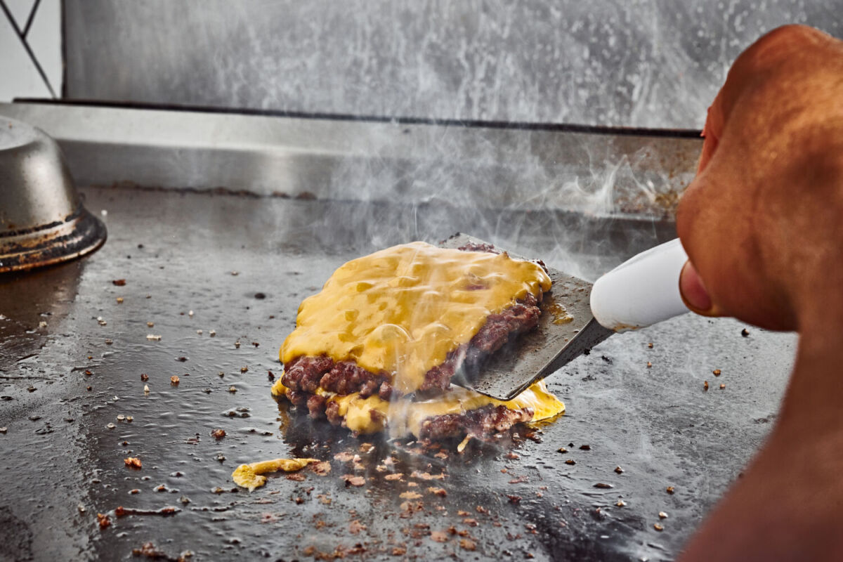 Queso derretido sobre la carne de una hamburguesa 