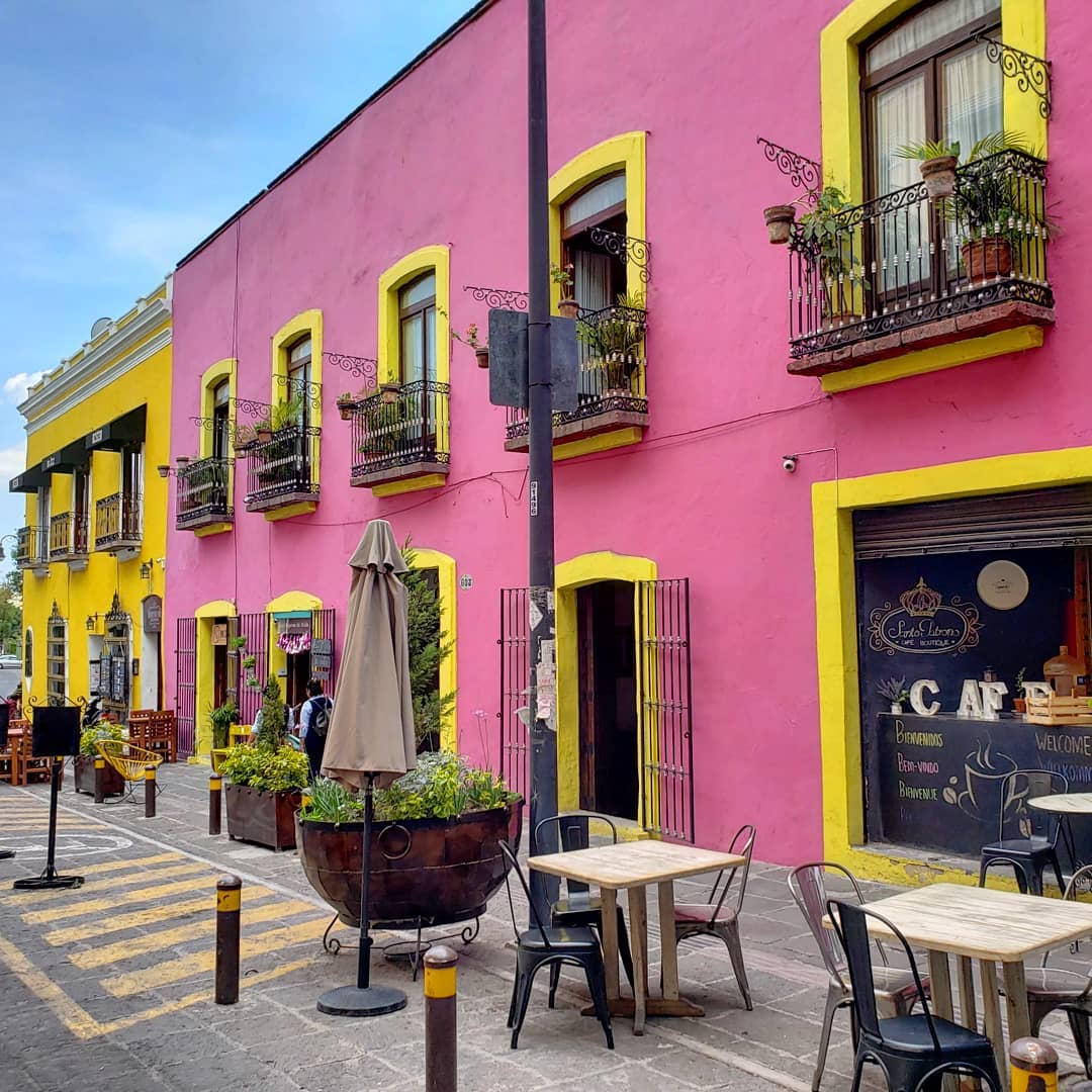 calle colorida con mesas al aire libre 