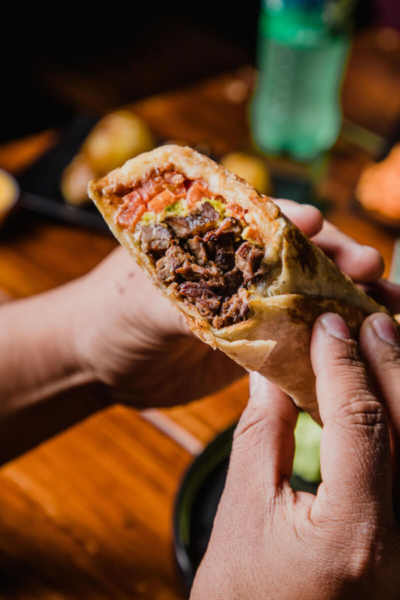 persona sosteniendo un burrito 