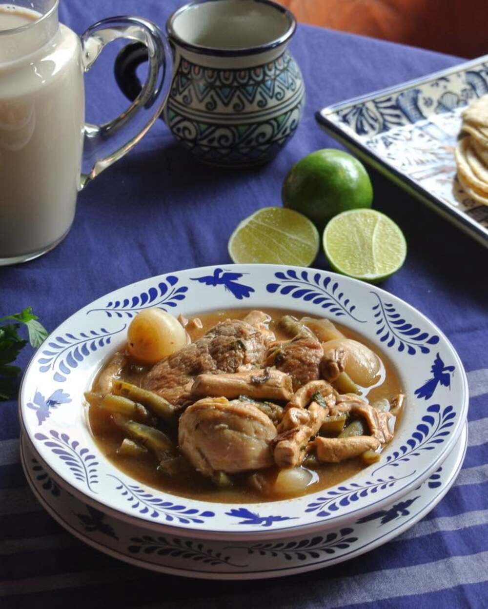 sopa mexicana con pollo servida en un plato con detalles azules