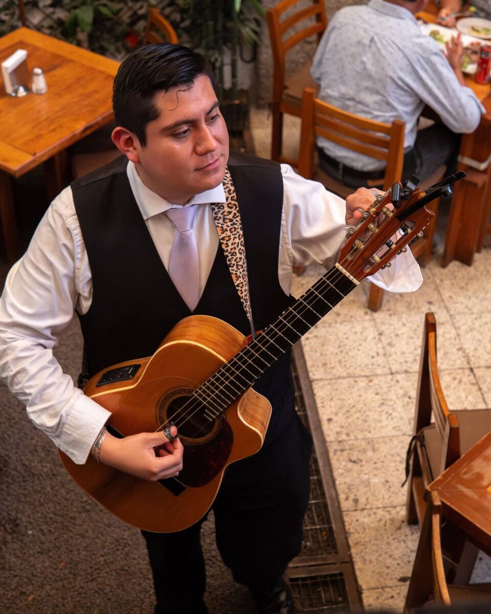 hombre tocando guitarra en un restaurante