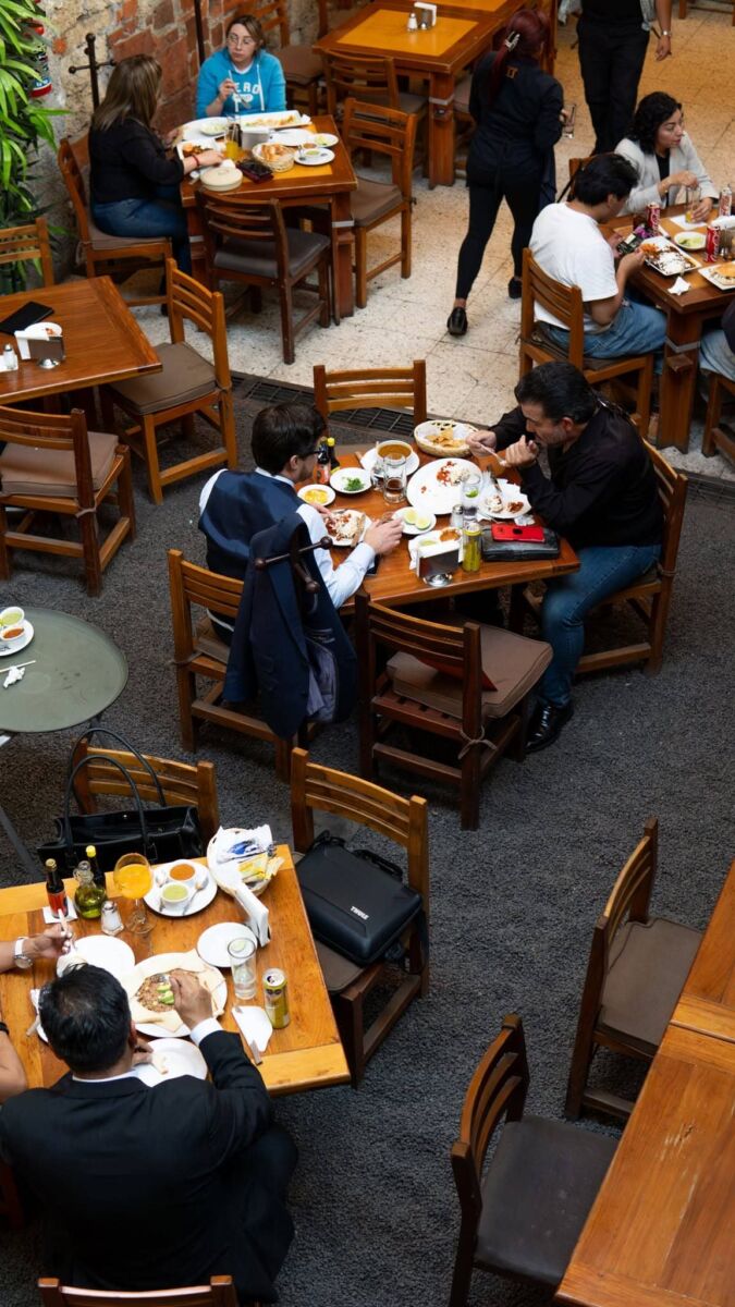 restaurante mexicano con mesas de madera y gente comiendo