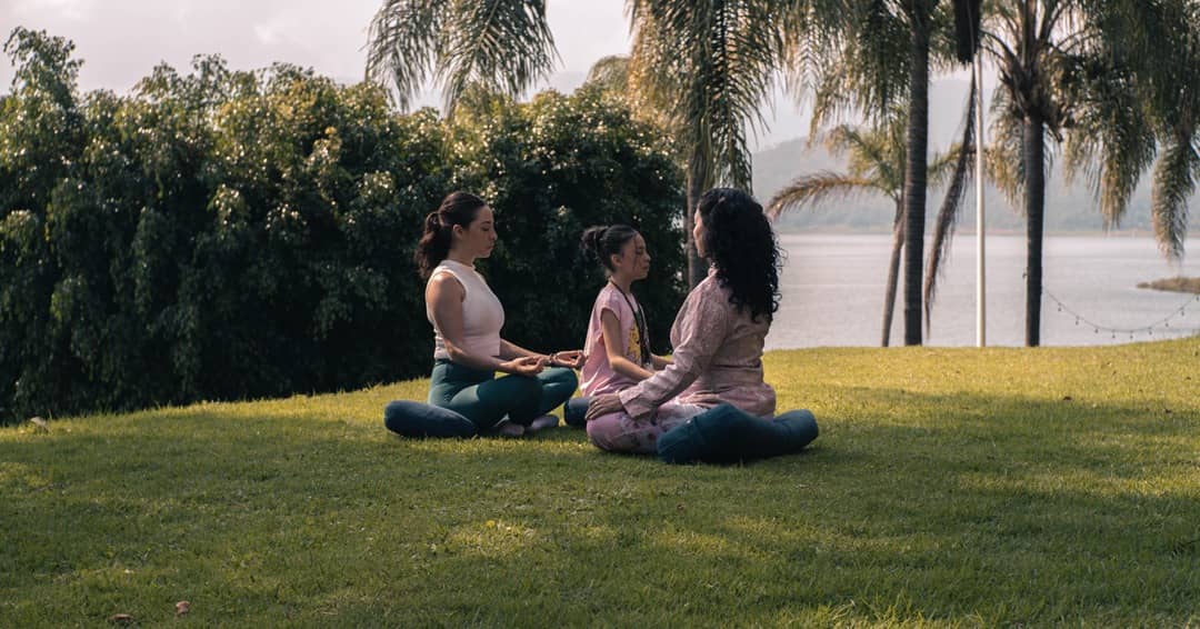 madre e hija en una sesión de meditación al aire libre