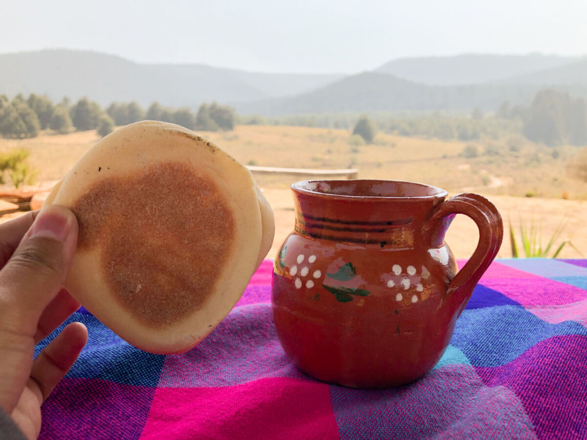 gordita de nata y café servido en una olla de barro 