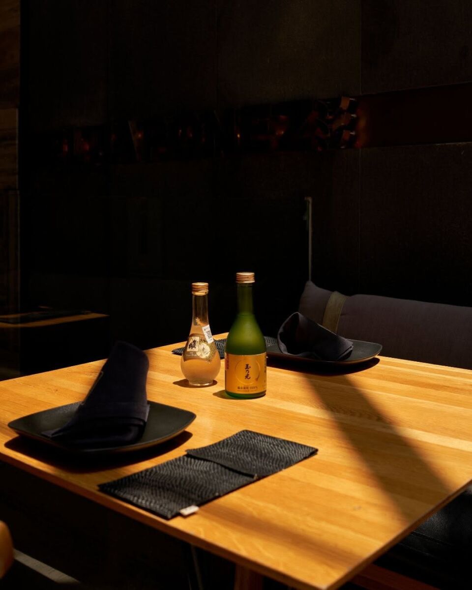 mesa de madera con platos y servilletas negros en restaurante El Japonez