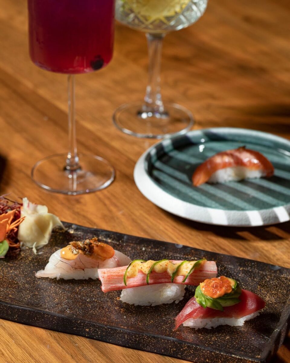 nigiris de diferentes pescados con copas de vino rosado y blanco en El Japonez