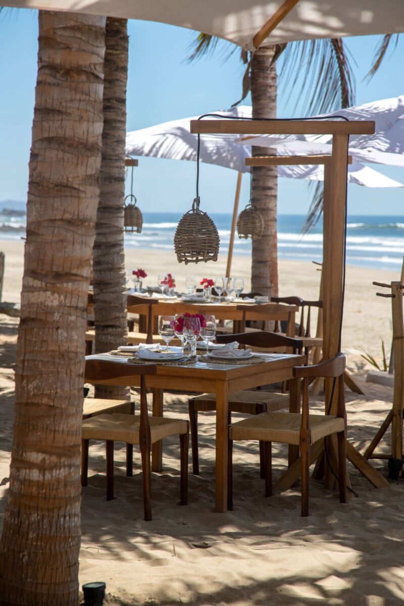 restaurante en la playa con mesas de madera