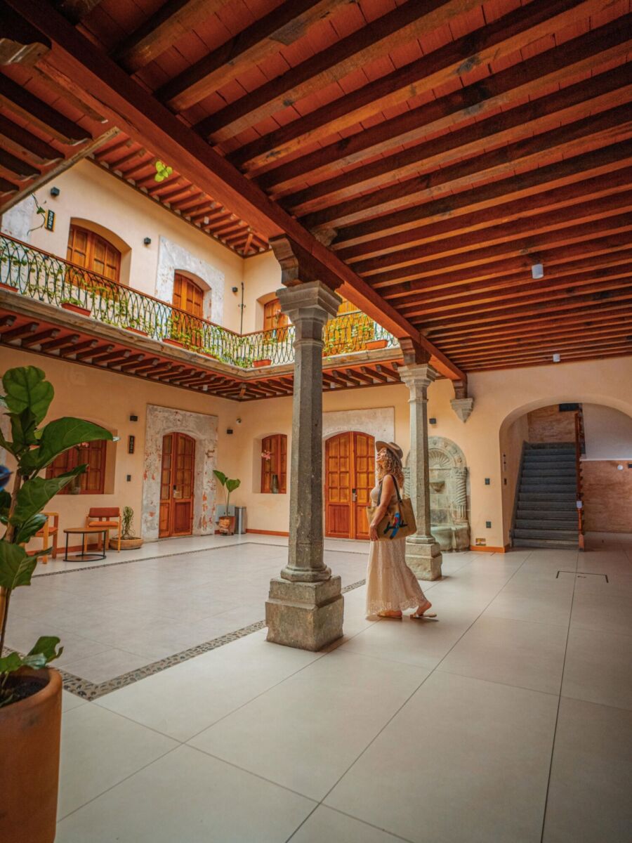 mujer entrando a un hotel en una casona antigua en oaxaca