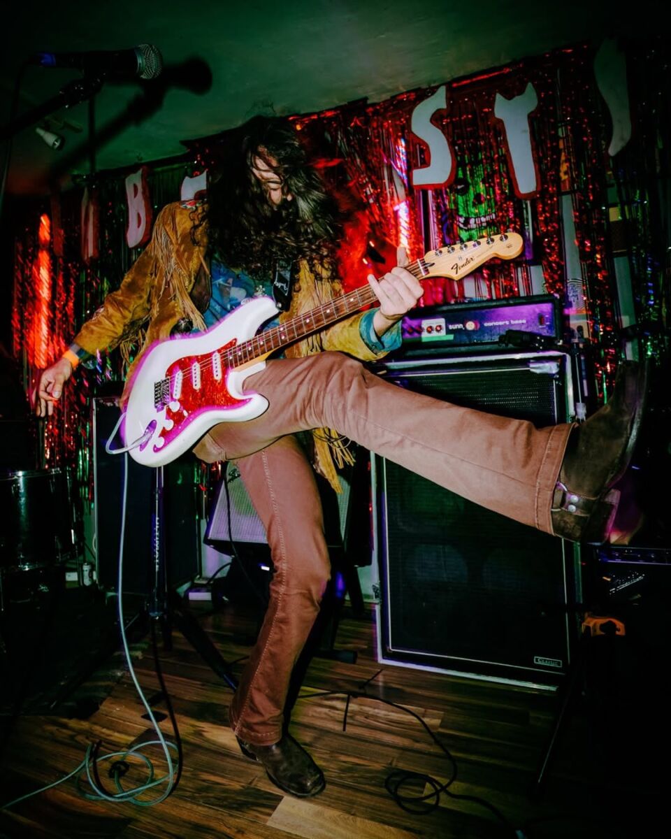 guitarrista bailando en medio de un concierto