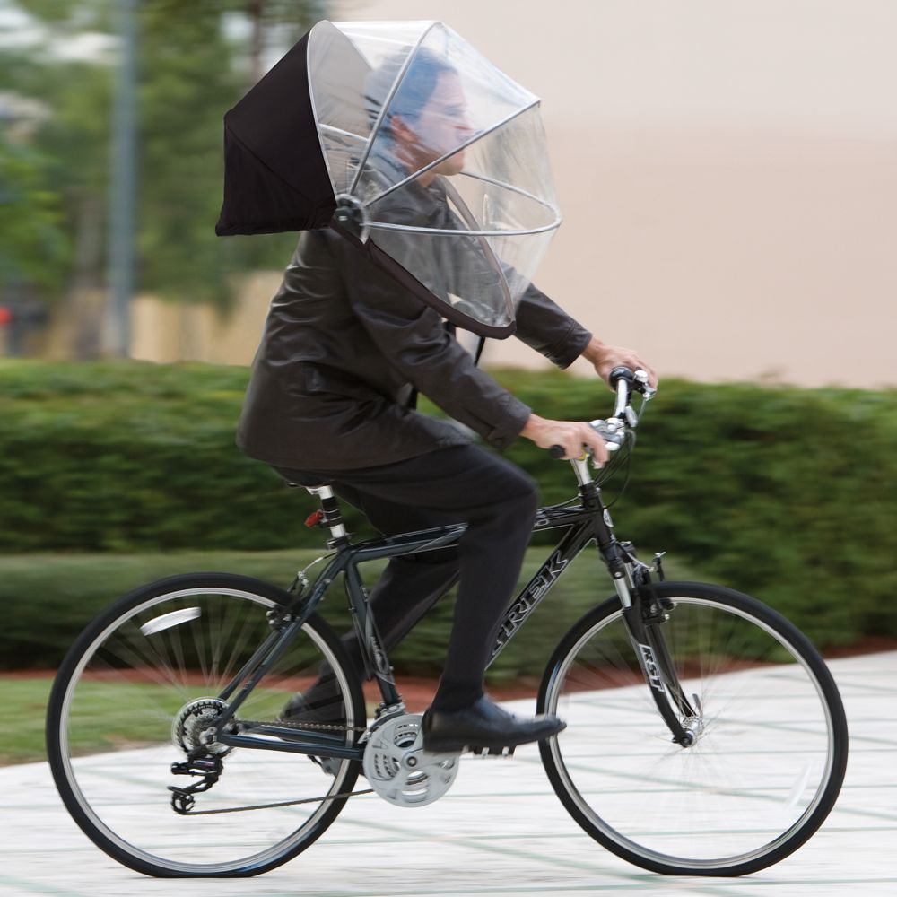 Ciclista con paraguas tipo casco que cubre cabeza y hombros, diseño Nubrella para manos libres