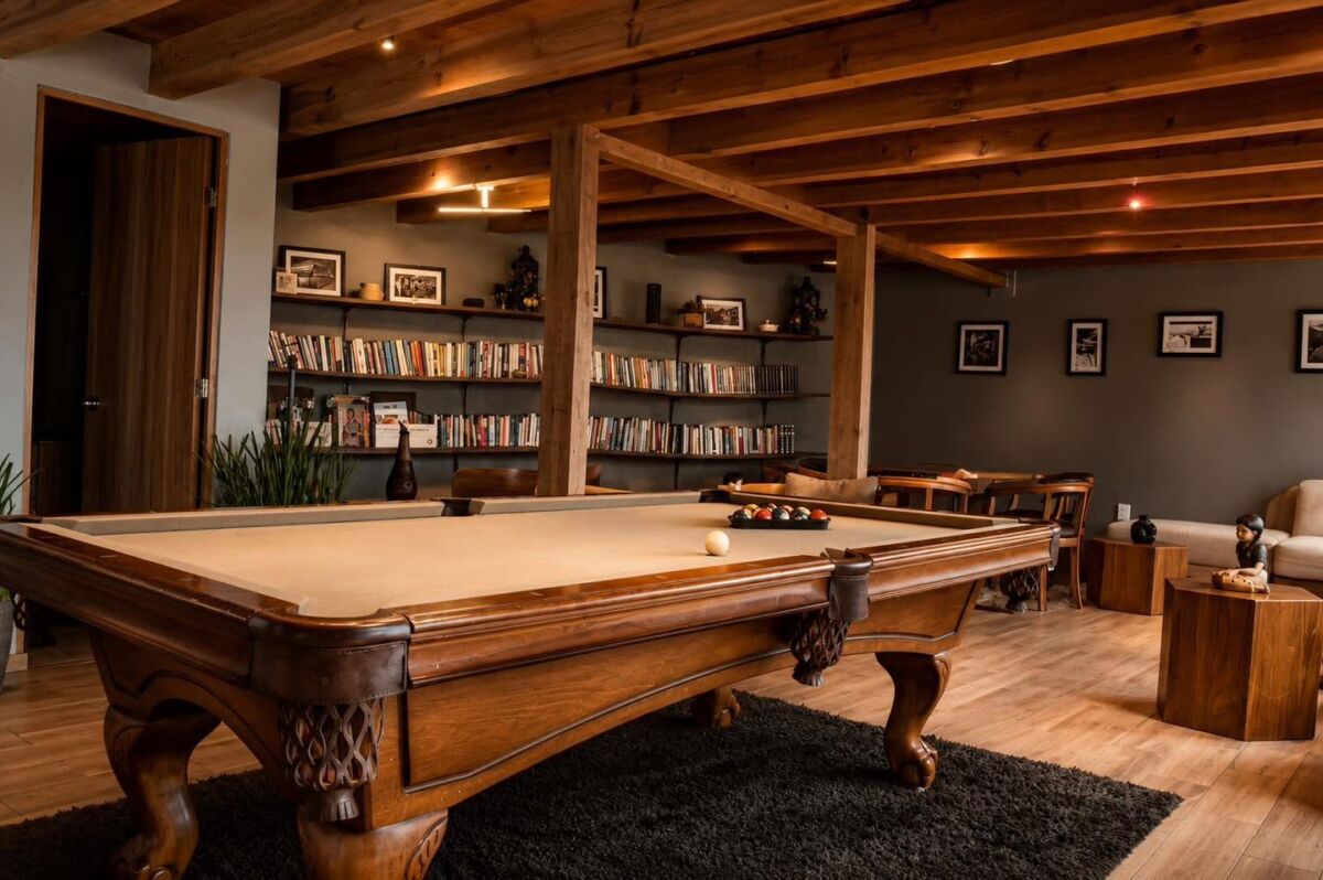 casa club de hotel con libros y mesa de billar