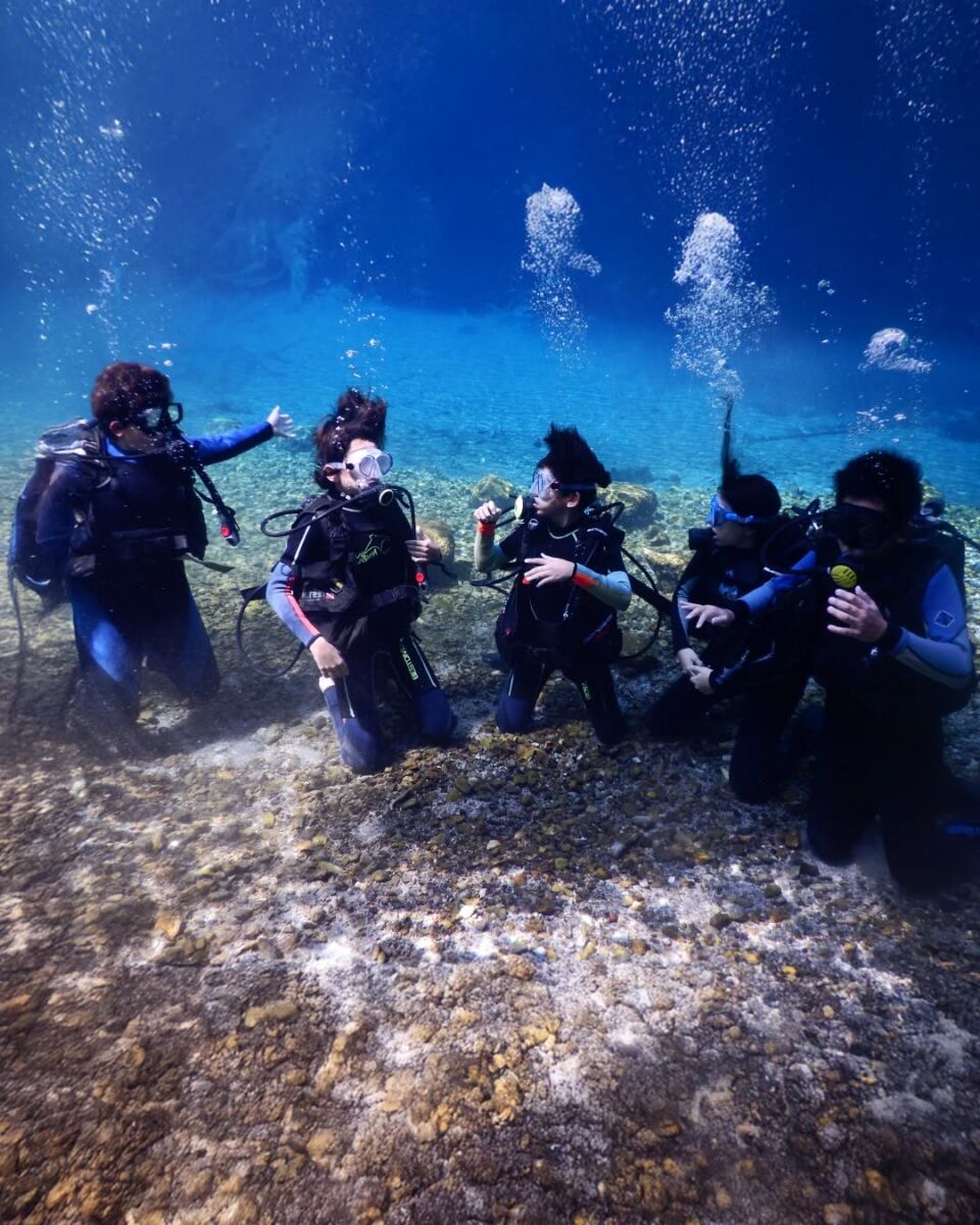 personas haciendo snorkeling en manantial natural