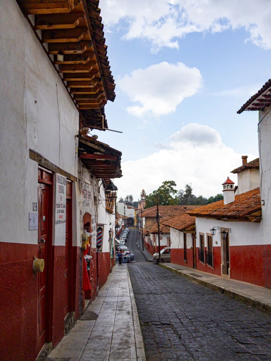 calle empedrada rodeada de casonas de fachada blanca y tejas rojas