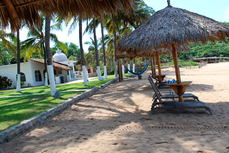 palapa y camastros en la playa