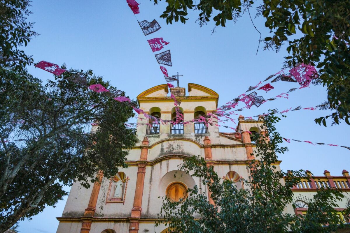 fachada de una parroquia decorada con papel picado