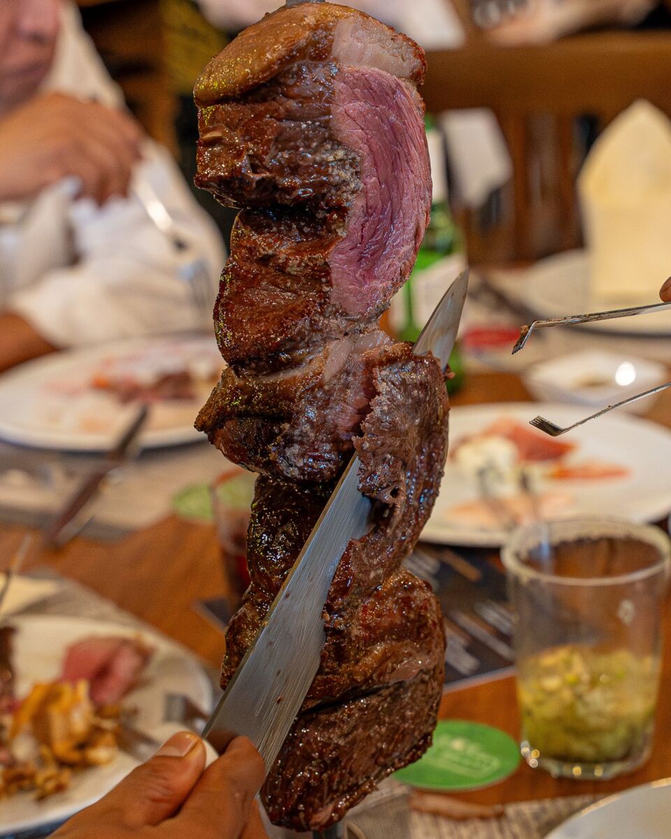 carne jugosa en espada siendo cortada para una mesa
