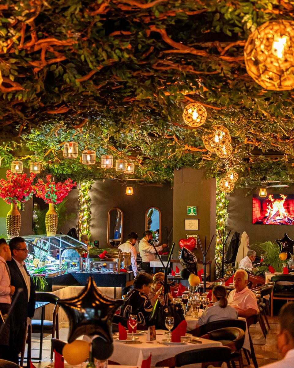 árbol grande con ramas y lamparas colgando en restaurante