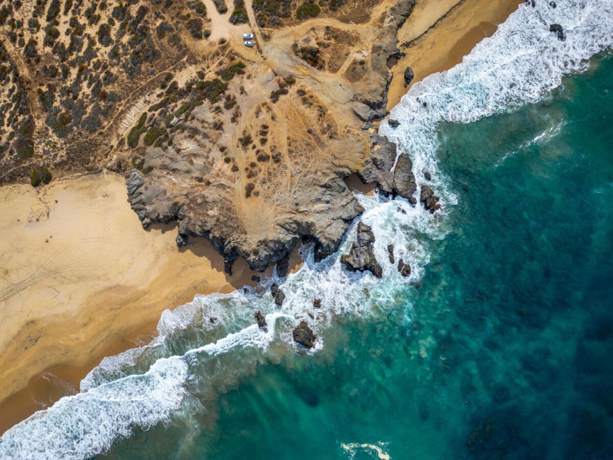 Vista aérea de la costa rocosa de San José del Cabo con olas rompiendo sobre acantilados de arena