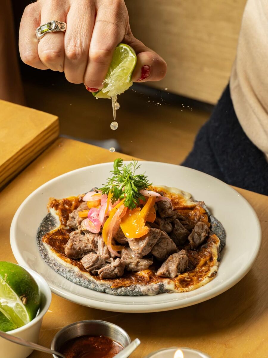 persona poniendo limón a su taco