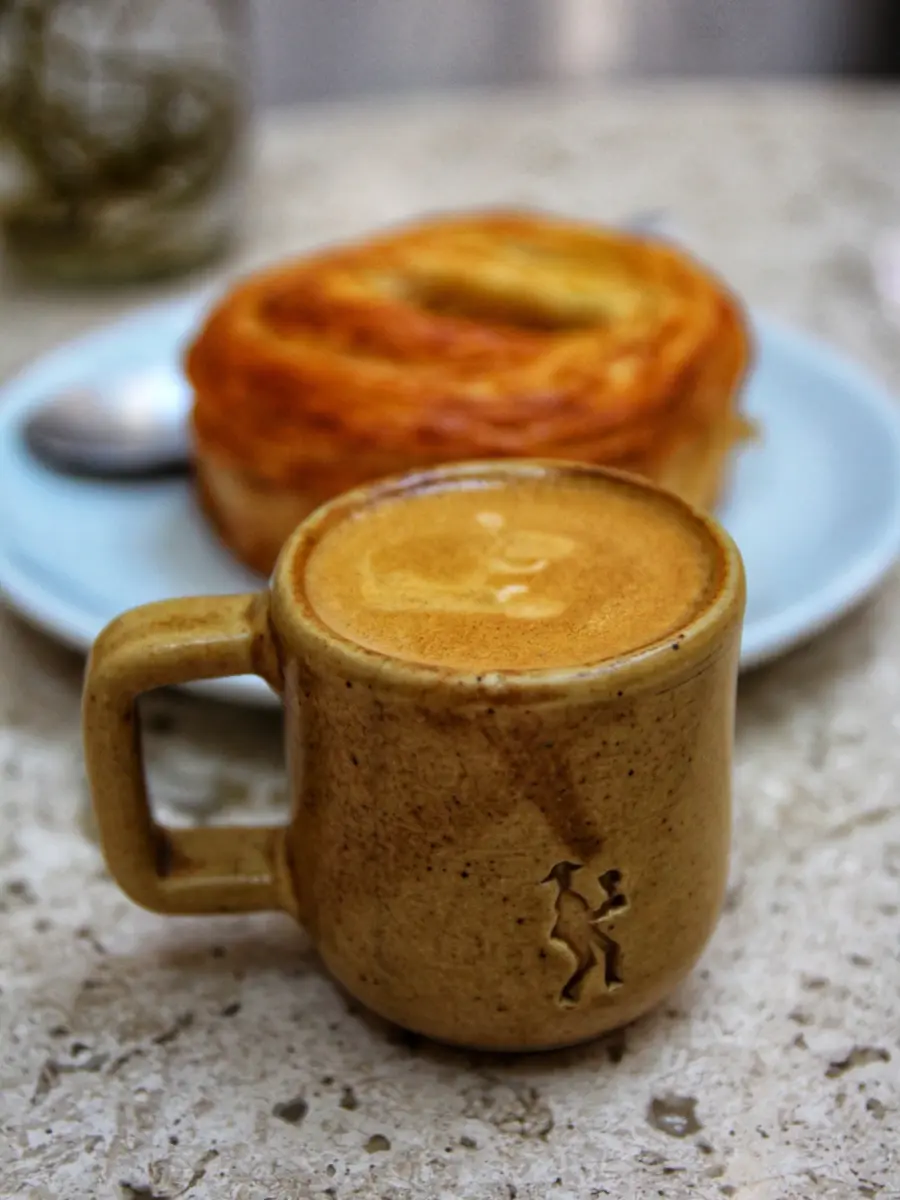 taza con bebida caliente de chile y un pan dulce