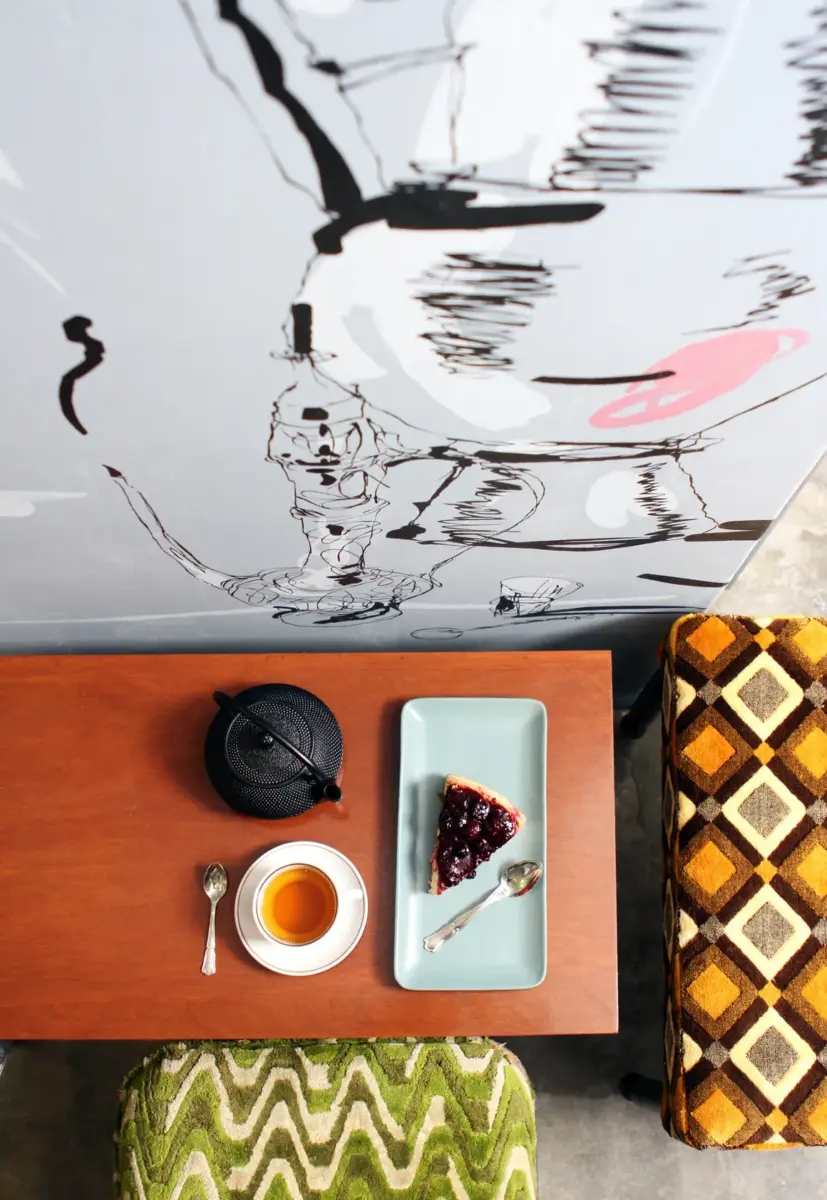 tetera con cheesecake de frutos rojos con pared decorada