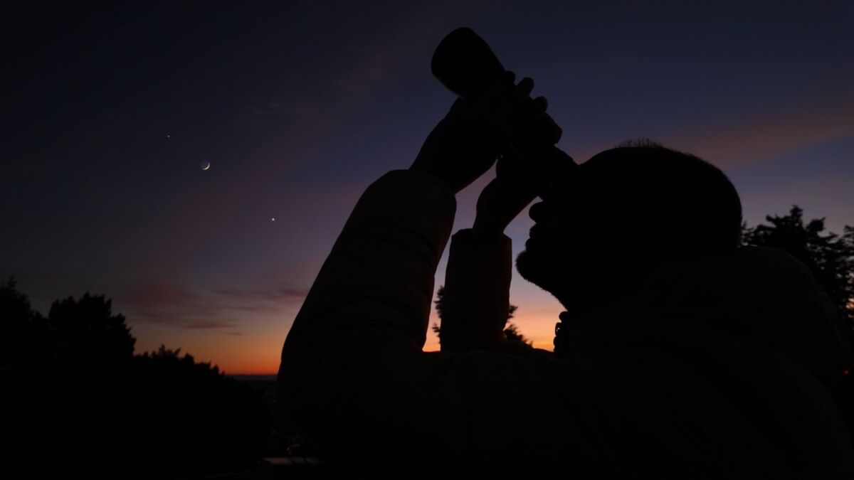 persona observando el cielo con binoculares