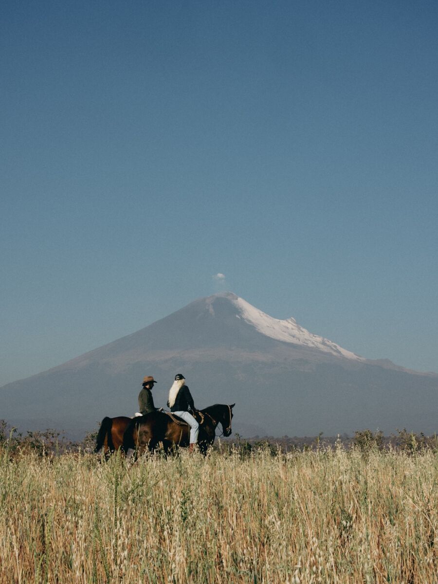 pareja cabalgado a las faldas del volcán Popocatépetl 