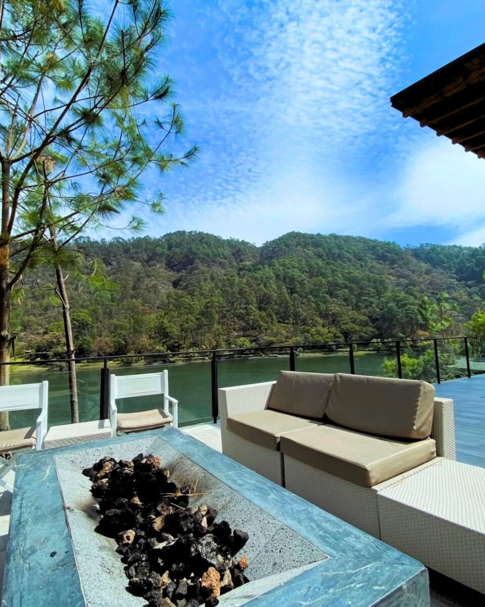 Terraza con fogatero y vista a un lago